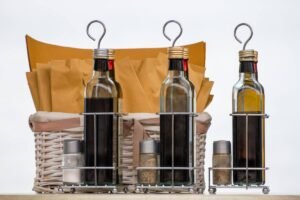 Fles azijn naast een plantenspuit op een tafel