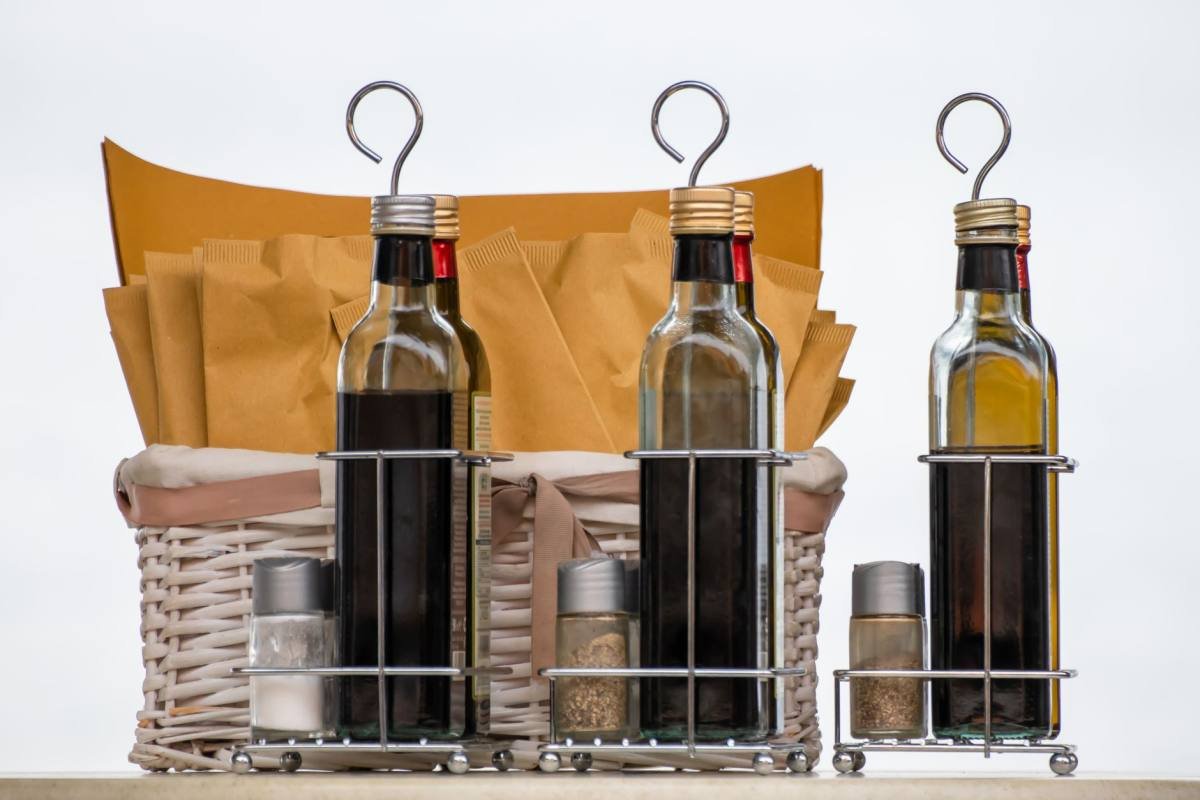 Fles azijn naast een plantenspuit op een tafel