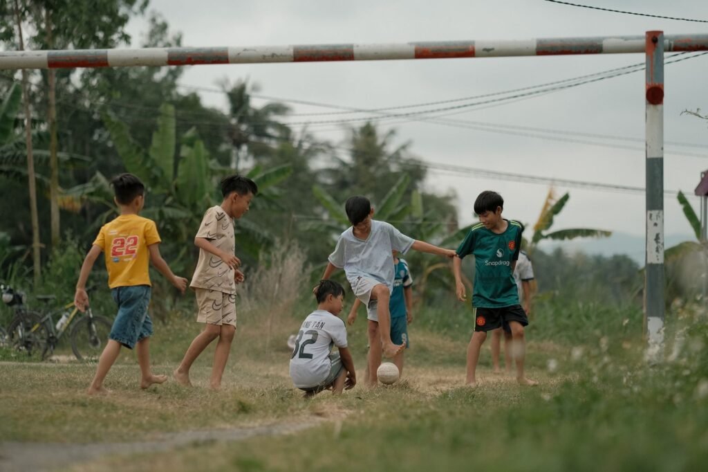 Jongens voetballen op een groen grasveld