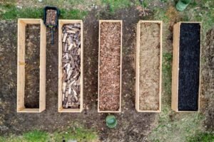 Laag donkere compost uitgespreid over een moestuinbed
