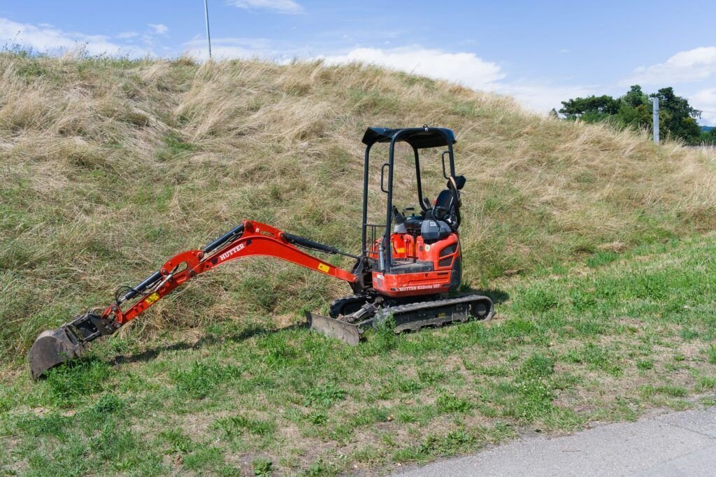 Minigraver die een gat graaft in een tuin